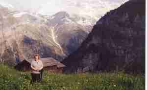 Mom Outside Our Chalet B&B.  Just behind her, the hillside drops off a gigantic cliff to the valley below.
