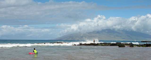 Here is the spectacular view at our beach.  The mountains in the distance are the West Maui Mountains.  Notice the windfarm climbing up the ridge.  The older man standing on the lava point was about as close as you could get the pounding surf without being swept away ... maybe too close!